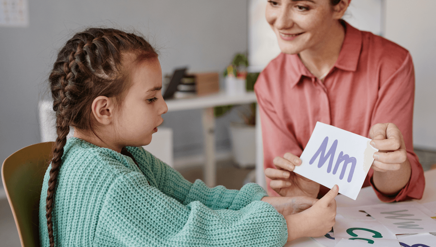 A lady helping a child work on a laptop