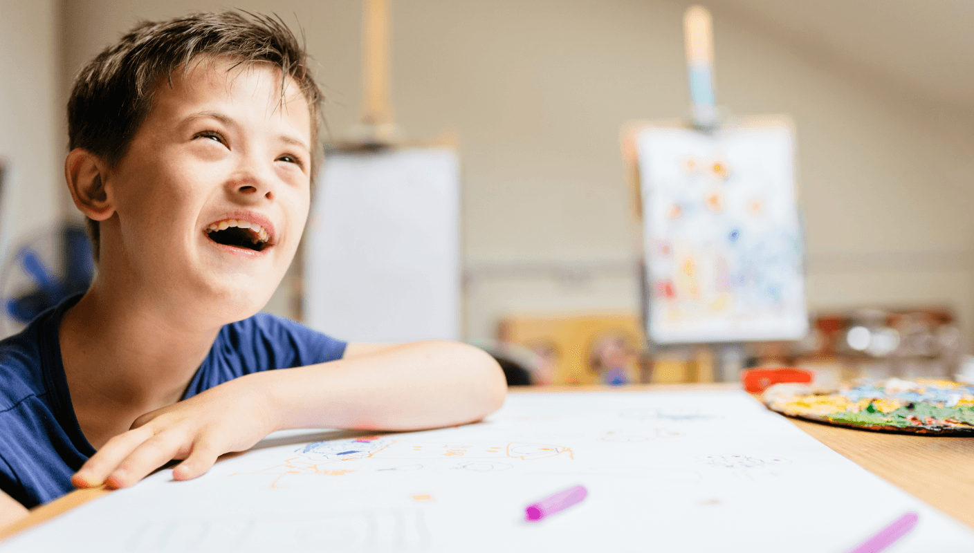 A young child working on a tablet in a wheelchair