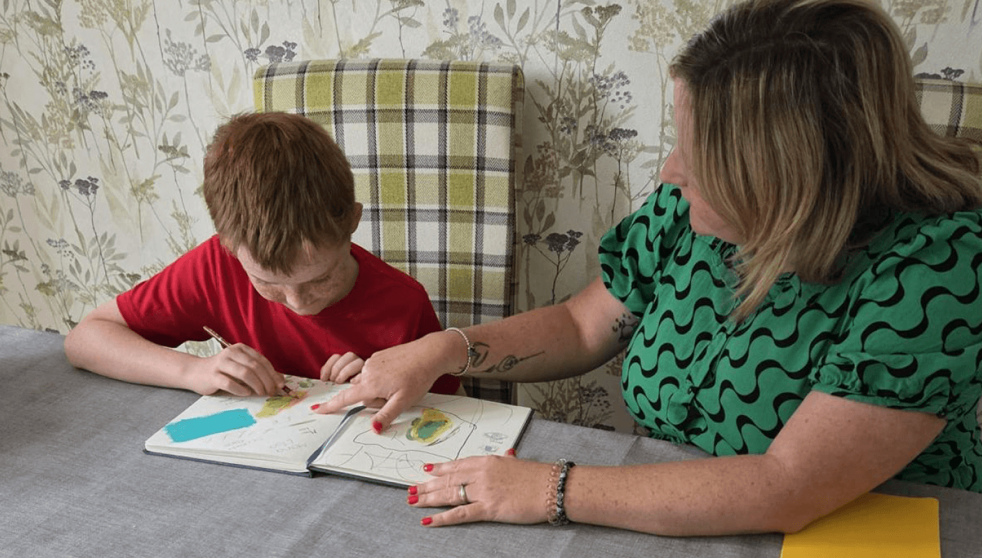 A woman studying with a child