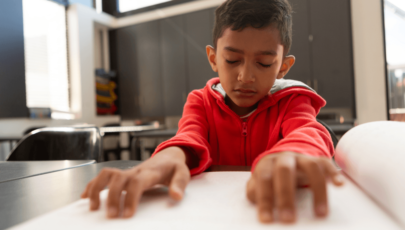 A young child working on a tablet in a wheelchair