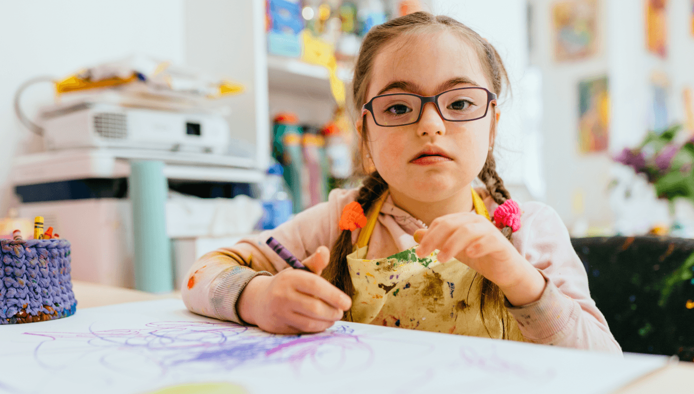 A young child working on a tablet in a wheelchair