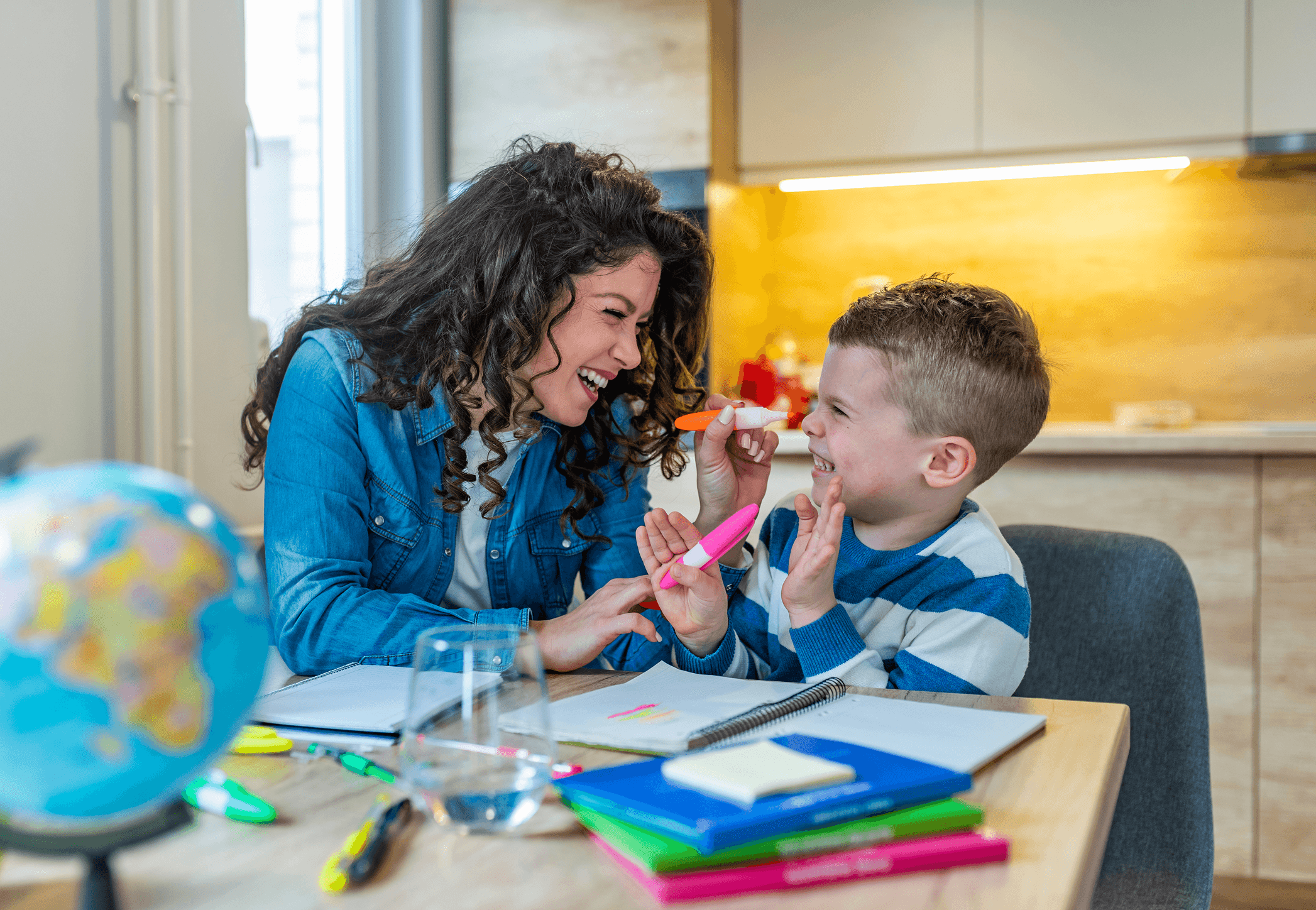 A tutor and child playing together with highlighter pens