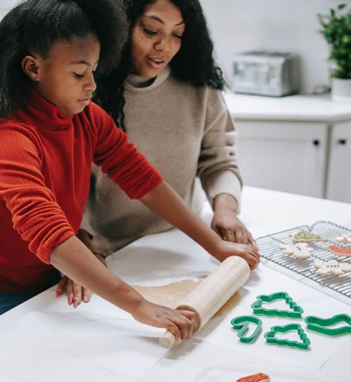 young girl baking with mother to learn