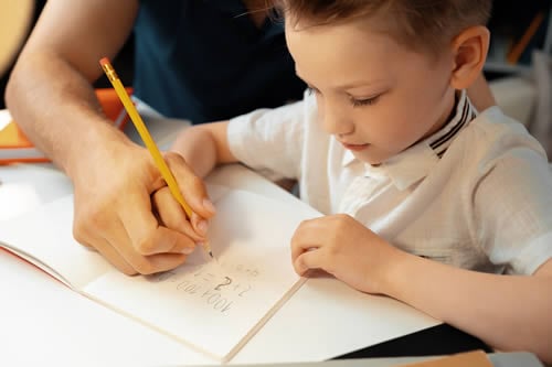 teacher helping child to write