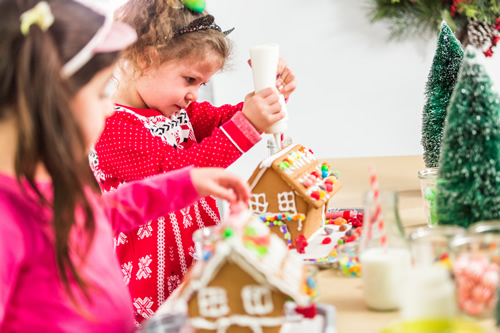 children making gingerbread houses at christmas