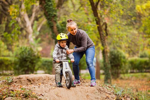 parent helping child off-road biking