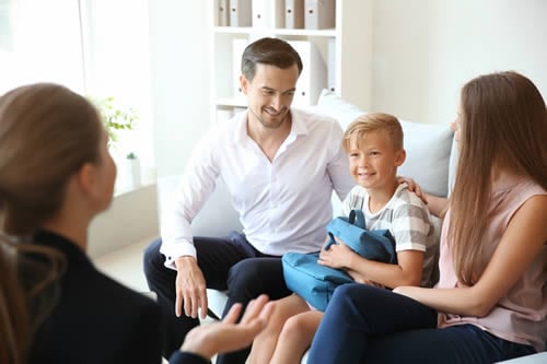 parents happliy discussing student with teacher