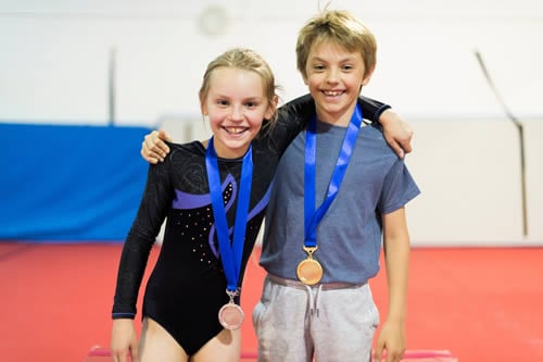 children wearing medals after winning gymnastics competition