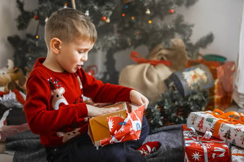 child unwrapping presents