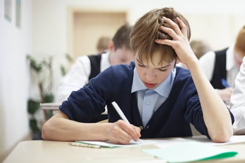 boy struggling to do work in classroom