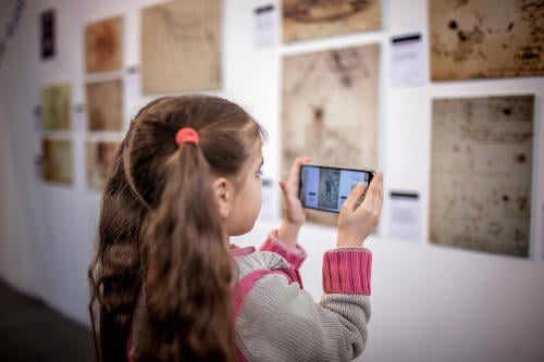 Curious girl exploring a contemporary art exhibition with augmented reality