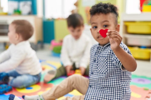 child holding heart shape at nursery