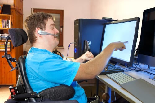 Man with infantile cerebral palsy using a computer.