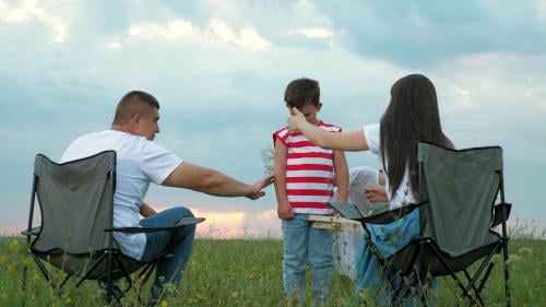 Family consoling child on camping trip