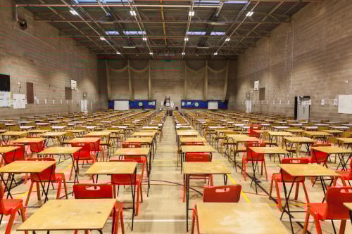 Exam tables set up in a sports hall for exams in a high school & sixth form