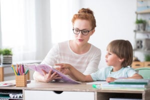 Young boy doing homework with tutor