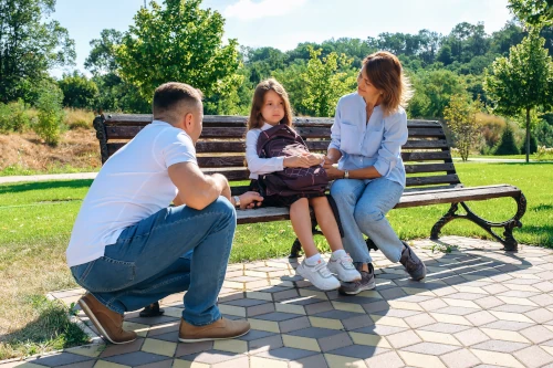 parents discussing school avoidance issues with daughter on a bench