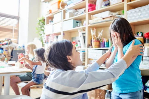 teacher helping upset child at school