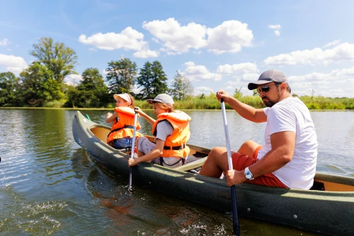 kids on canoe in summer camp with instructor