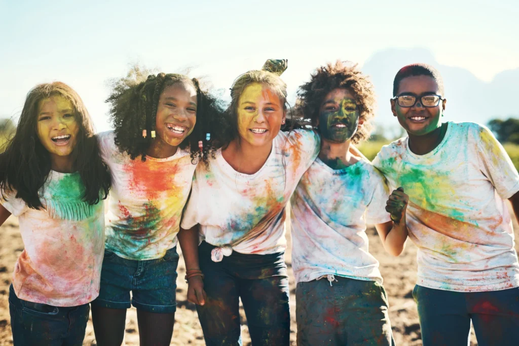 kids from a SEND summer camp posing for the camera with paint down them
