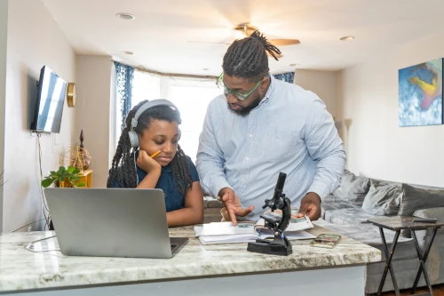 parent homeschooling child with laptop